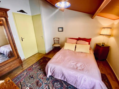 a bedroom with a large bed with red pillows at Maison de plage à 100m de la mer in Talmont