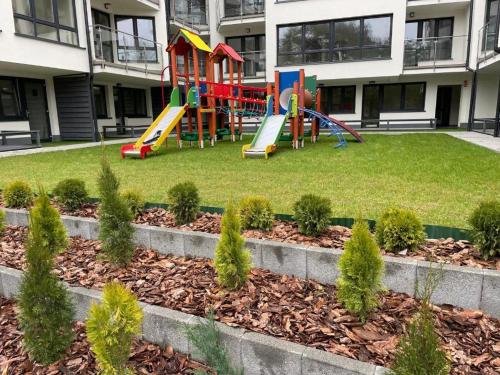 un parque infantil frente a un edificio de apartamentos en Apartamenty Wypoczynkowa 3, en Rowy