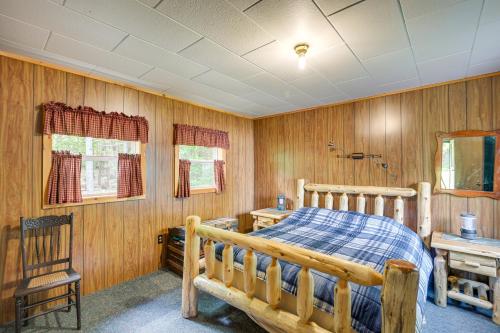 um quarto com uma cama, uma mesa e uma cadeira em Peaceful Lakefront Cabin Getaway Dock, Fire Pit! em Island Falls