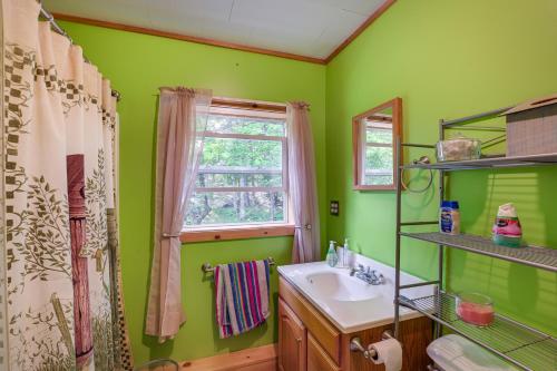 uma casa de banho verde com um lavatório e uma janela em Peaceful Lakefront Cabin Getaway Dock, Fire Pit! em Island Falls