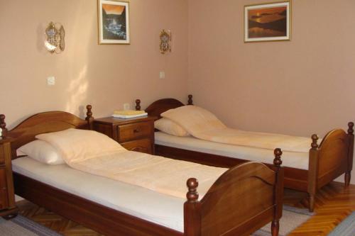 a room with three beds and a nightstand at Saraj Guest House in Kulen Vakuf