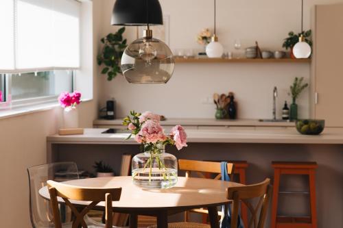 - une table à manger avec un vase de fleurs dans l'établissement Apartments Marinka Litomyšl, à Litomyšl