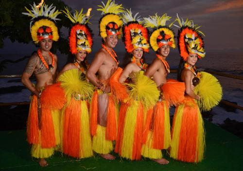 eine Gruppe von Männern und Frauen in Orange und Gelb in der Unterkunft Royal Kona Resort in Kailua-Kona