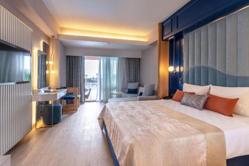 Una habitación de hotel con una cama grande y un escritorio. en Lago Hotel, en Side