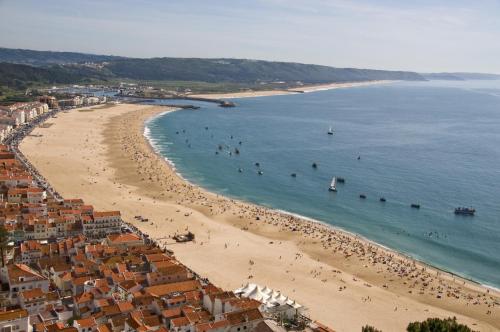 a view of a beach with people in the water at NorthSpot in Nazaré