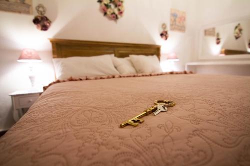 Una llave dorada sobre una cama en La Corte Della Regina, en Catania