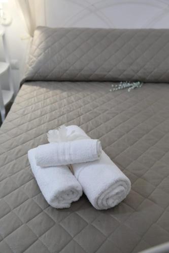 a pile of towels sitting on a bed at La Maison Piazza del Popolo in Manfredonia