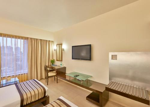 Pokój hotelowy z łóżkiem i biurkiem w obiekcie Krishna Palace Hotel w Bombaju