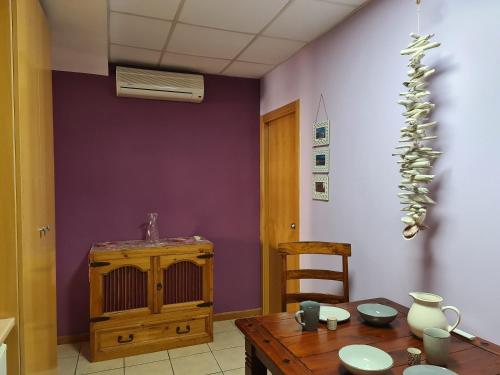 une salle à manger avec une table et un mur violet dans l'établissement Pension Die kleine Auszeit, à Dénia