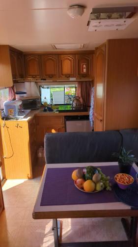 una cocina con una mesa con un bol de fruta. en Hausboot Pretty Belinda, en Wessem