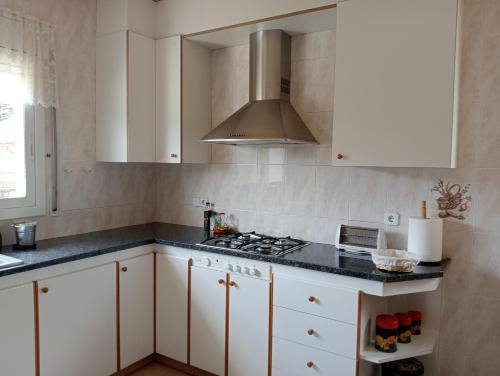 eine Küche mit weißen Schränken und einem Herd mit Backofen in der Unterkunft Apartamento-Casa turística l'Espígol in San Lorenzo de Morunys