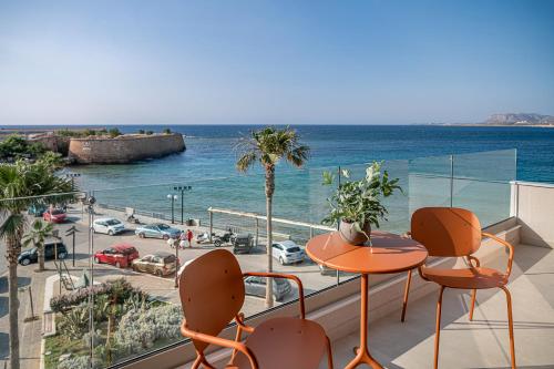 uma varanda com mesa e cadeiras e vista para o oceano em Theta Boutique Hotel em Chania Town