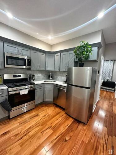 cocina con nevera de acero inoxidable y suelo de madera en Renovated Private 1B/1B w/ Kitchen en Filadelfia