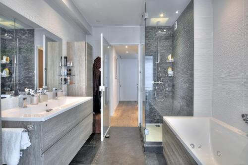 a bathroom with two sinks and a tub and a shower at Le Florentina, dernier étage avec terrasse, vue sur la Baie des Anges in Nice