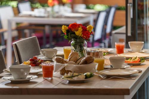 a table with food and a vase of flowers at Hotel Villa Lago Garni in Bad Wiessee