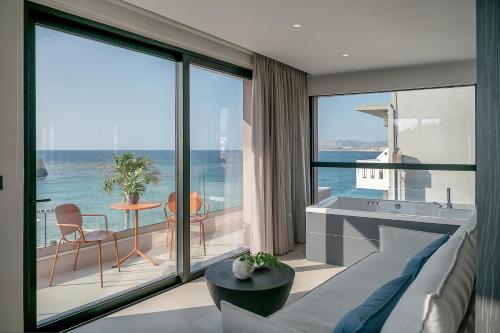 a living room with a couch and a view of the ocean at Theta Boutique Hotel in Chania