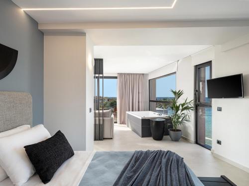 a bedroom with a bed and a bathroom with a tub at Theta Boutique Hotel in Chania Town