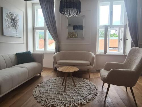 a living room with a couch and two chairs and a table at Elegant bourgeois apartment in Kamnik