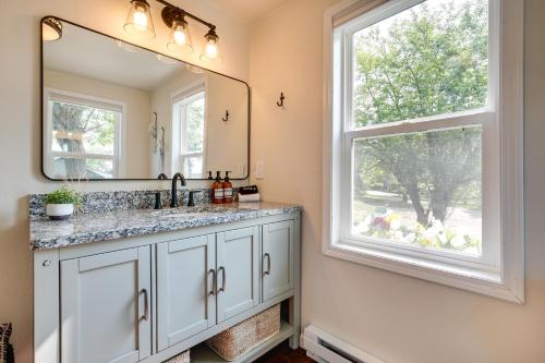 a bathroom with a sink and a mirror and a window at Eagle River Retreat Near Dam Lake with Boat Dock! in Eagle River