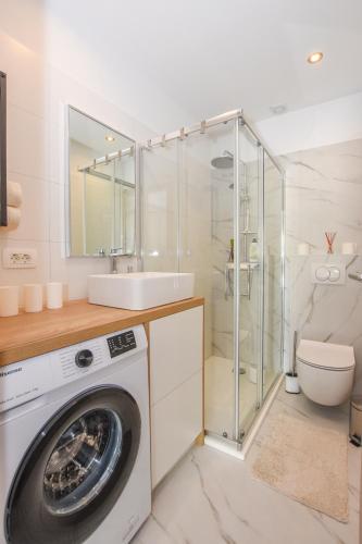 a bathroom with a washing machine and a sink at Apartment Sidro in Pag