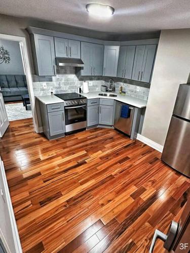 a kitchen with wooden floors and white cabinets at Renovated Private 1B/1B W/ Kitchen in Philadelphia