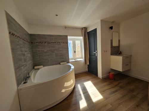 La grande salle de bains est pourvue d'une baignoire et d'un lavabo. dans l'établissement Rue des Tilleuls, à Saint-Marcel-lès-Sauzet