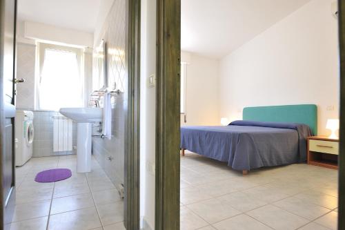 a bedroom with a bed and a sink and a bathroom at Arbatax Le Terrazze sul Mare in Àrbatax