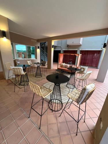 a room with tables and chairs on a patio at Hotel St Gregory Park in Rimini
