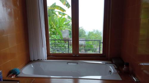 a bath tub in a bathroom with a window at Private Villa - Ocean, hills, valley view in Temukus