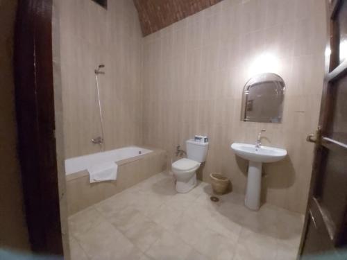 a bathroom with a sink and a toilet and a bath tub at Sekhmet Retreat Centre in Luxor