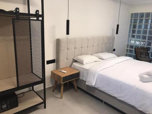 Un dormitorio con una gran cama blanca y una mesa en Hotel Argo, en Siviri