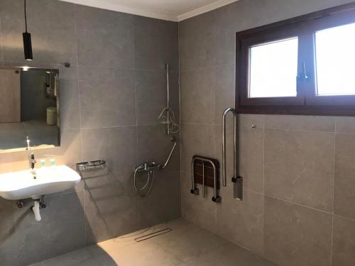 ein Bad mit einem Waschbecken und einer Dusche in der Unterkunft Hotel Argo in Siviri