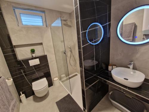 uma casa de banho com um WC, um lavatório e um espelho. em Summerhouse Liber em Mlini