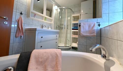a bathroom with a bath tub and a sink at Captain's Cabin Piran - free parking in Piran