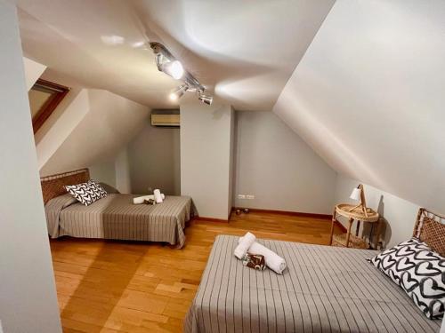 a attic room with two beds and a chair at Apartamento 1 in Madrid