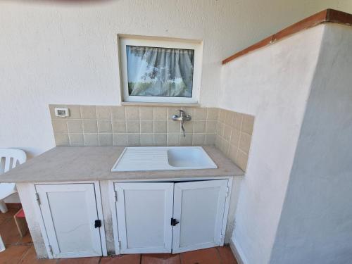 a bathroom counter with a sink and a window at Villa Temistocle in Torre Santa Sabina