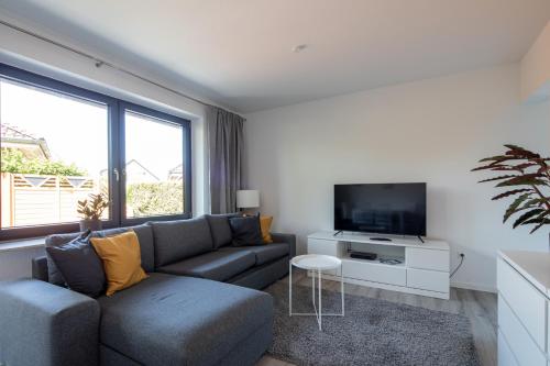 uma sala de estar com um sofá e uma televisão de ecrã plano em Ferienwohnung Seebär em Wangerland