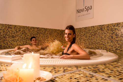 a man and a woman in a bath tub at Hotel Tiski Cvet in Novi Bečej