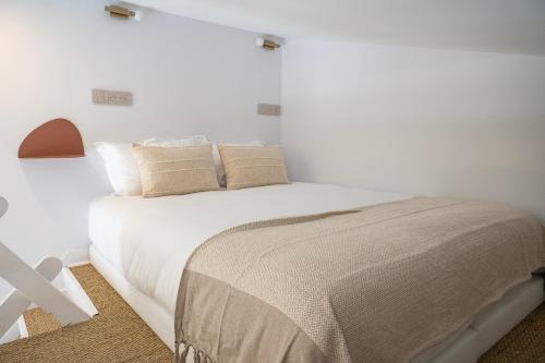 サントロペにあるCharmant Studio - C1の白いシーツと枕が備わったベッドのある寝室