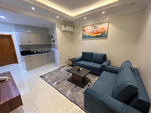 sala de estar con sofá azul y mesa en مساكن الراحة en Abha
