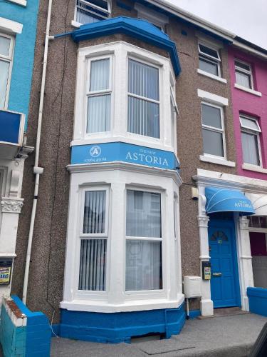 Un edificio de apartamentos con una ventana azul y blanca. en The New Astoria Hotel, en Blackpool
