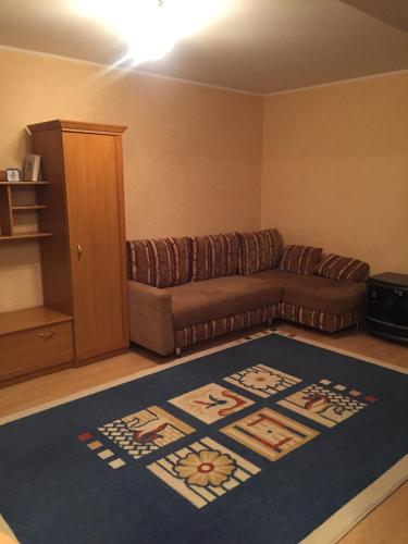 een woonkamer met een bank en een tapijt bij Однокомнатная квартира посуточно in Balqash