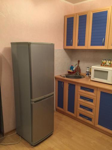 a kitchen with a refrigerator and a microwave at Однокомнатная квартира посуточно in Balqash