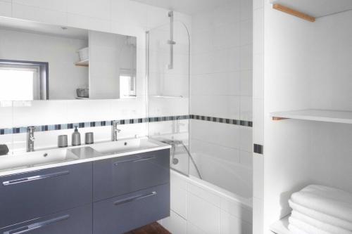 a white bathroom with a sink and a bath tub at La Demeure de Chemonton - 6 personnes, 2 chambres in Blois
