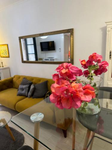 een woonkamer met een glazen tafel met bloemen in een vaas bij Apartment Banovac 1 in Dubrovnik