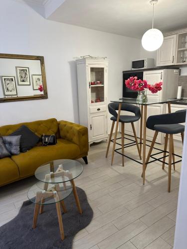 uma sala de estar com um sofá amarelo e uma mesa em Apartment Banovac 1 em Dubrovnik