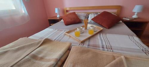 a bed with two cups and a tray of food on it at Holiday house and apartments Vale in Duga Resa
