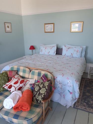 a bedroom with a bed and a couch with pillows at Grantham House in Ryde