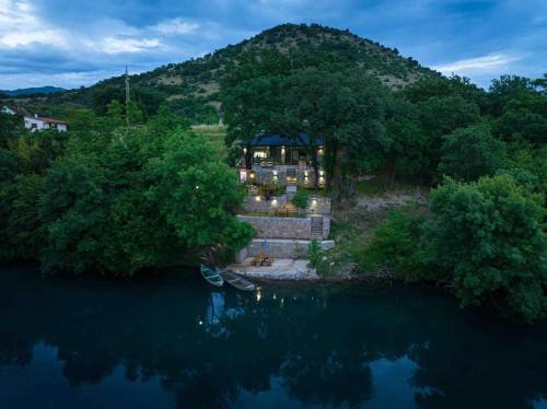 a house on a hill next to a body of water at Rijeka Zeta, Podgorica in Podgorica