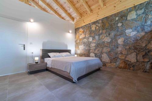 a bedroom with a bed and a stone wall at Rijeka Zeta, Podgorica in Podgorica